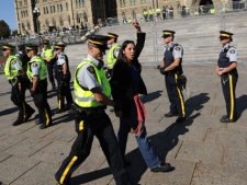 Police escort a protester at a rally against the Keystone XL pipeline on Parliament Hill in Ottawa on Monday, Sept. 26, 2011. (THE CANADIAN PRESS/Sean Kilpatrick)