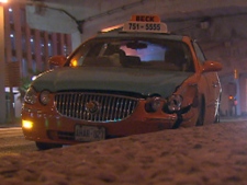 A damaged taxicab rests at Lake Shore Boulevard and Bay Street after it was stolen from its driver and involved in a collision early Monday, Sept. 26, 2011.