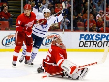 Toronto Maple Leafs left wing Clarke MacArthur, center, celebrates a goal in overtime by Mike Komisarek against Detroit Red Wings goalie Jimmy Howard (35) as left wing Justin Abdelkader (8) reacts during an NHL preseason hockey game on Friday, Sept. 30, 2011, in Detroit. Toronto won 4-3 in overtime. (AP Photo/Rick Osentoski)