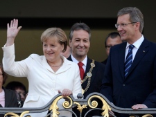 German Chancellor Angela Merkel, left, President Christian Wullf, right, and Mayor of the former German capital Bonn, Juergen Nimptsch, center, stand on the balcony of the city hall during celebrations that mark the reunification of Germany 21 years ago, in Bonn, Germany, Monday, Oct. 3, 2011. (AP Photo/dapd, Mark Keppler)