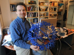 In this Sept. 19, 2008, handout photo provided by the John D. and Catherine T. MacArthur Foundation, astronomer Adam Riess sits in his office at Johns Hopkins University in Baltimore. (AP Photo/The John D. and Catherine T. MacArthur Foundation, Gail Burton)