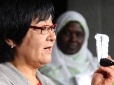 Minister of International Cooperation Bev Oda holds up a sample of zinc and oral rehydration salts as Dr. Mame Mbayame Gueye Dione, head of the Senegal Ministry of Health's Devision of Food, Nutrition and Child Survival looks on as they take part in a press conference on Parliament Hill in Ottawa on Monday, June 27, 2011. (THE CANADIAN PRESS/Sean Kilpatrick)