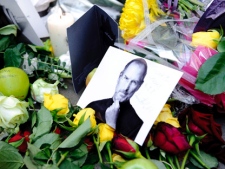 Tributes to Apple co-founder Steve Jobs are placed outside an Apple Store on Regent Street in London, England. (AP Photo/Jonathan Short)