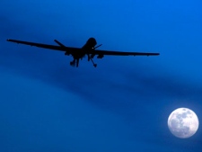 In this Jan. 31, 2010 file photo, an unmanned U.S. Predator drone flies over Kandahar Air Field, southern Afghanistan, on a moon-lit night. A computer virus that captures the strokes on a keyboard has infected networks used by pilots who control U.S. Air Force drones flown on the warfront, according to a published report. (AP Photo/Kirsty Wigglesworth, File)
