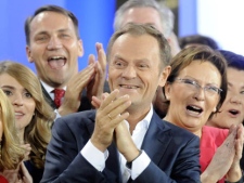 Prime Minister Donald Tusk, center, celebrates with Health Minister Ewa Kopacz, right, and Foreign Minister Radek Sikorski, background left, as the first exit poll is published during the election party of Tusk's Civic Platform, a centrist and pro-EU party, in Warsaw Sundey, Oct. 9, 2011. An exit poll shows that the centrist Civic Platform party of Prime Minister Donald Tusk is winning Poland's national election with 39.6 percent of the votes. (AP Photo/Alik Keplicz)