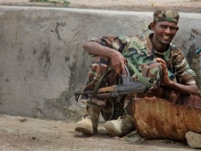A Somali government soldier takes up a position during clashes with Islamist militants in Mogadishu, Somalia Monday, Oct. 10, 2011. Heavy fighting broke out in Somalia's capital on Monday after pro-government forces attacked militant positions following what the African Union force said were the deaths of at least 12 Somali civilians because of militants' mortars. (AP Photo/Farah Abdi Warsameh)