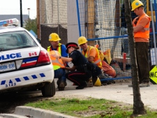 Police comfort a construction worker at the scene of a crane collapse at York University in Toronto on Tuesday, Oct. 11, 2011. A 25-year-old man was killed. (THE CANADIAN PRESS/Victor Biro)
