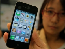The new Apple iPhone 4S is shown by a customer at a shop in Tokyo, Japan on Friday, Oct. 14, 2011. (AP Photo/Itsuo Inouye)