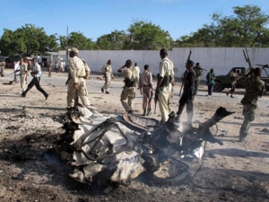 Somali government forces attend the scene of a car bomb in Mogadishu, Somalia Tuesday, Oct. 18, 2011. A suicide car bomb exploded near Somalia's Foreign Ministry on Tuesday, killing at least four people including the bomber, a police official said, on the same day that Kenya's ministers of defense and foreign affairs are in Mogadishu to meet with government leaders after Kenya on Sunday launched military operations in southern Somalia against al-Shabab militants. (AP Photo/Mohamed Sheikh Nor)