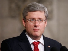Prime Minister Stephen Harper speaks to reporters in the foyer of the House of Commons in Ottawa Thursday, Oct. 20, 2011 about the death of long-time Libyan dictator Moammar Gadhafi. THE CANADIAN PRESS/Adrian Wyld