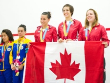 Canada's Miranda Ranieri, centre, Samantha Cornett, second right, and Stephanie Edminson, right, raise the Canadian flag after receiving their gold medal after defeating Colombia in women's team squash during the 2011 Pan American Games in Guadalajara, Mexico on Friday, Oct. 21, 2011. (THE CANADIAN PRESS/Nathan Denette)