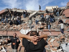 People try to save people trapped under debris in Tabanli village near the city of Van after a powerful earthquake struck eastern Turkey Sunday Oct. 23, 2011, collapsing some buildings and causing a number of deaths, an official said. ( AP Photo/ Abdurrahman Antakyali, Aatolia) 