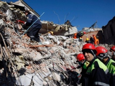 Turkish and Azeri rescuers search for victims in the debris of a collapsed building in Ercis, Van, Turkey, Friday, Oct. 28, 2011. The death toll was increased Friday as officials are able to gather more accurate information following the powerful quake which hit eastern Turkey on Sunday. (AP Photo/Burhan Ozbilici)