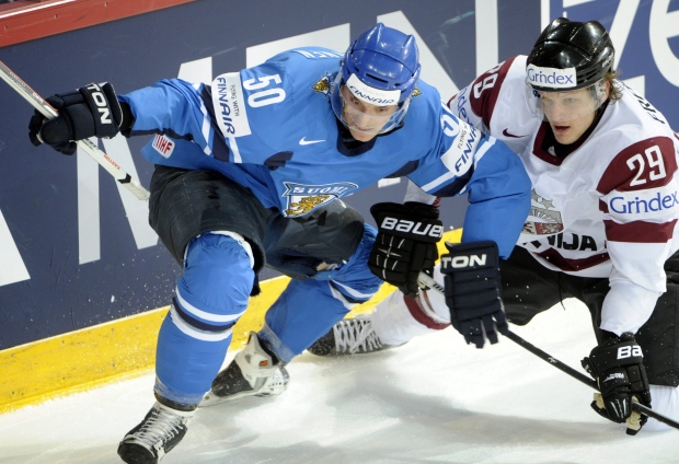 In this Tuesday, May 14, 2013, file photo, Finland's Juhamatti Aaltonen, left, vies for the puck with Latvia's Ralfs Freibergs during a 2013 IIHF World Championships Group B preliminary round match in Helsinki. (AP Photo/Lehtikuva, Jussi Nukari, File)