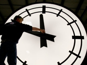 Electric Time machinist Scott Gow prepares to remove the hands of an eight-foot clock at the Electric Clock factory in Medfield Mass., March 9, 2007. (AP Photo/Stephan Savoia)