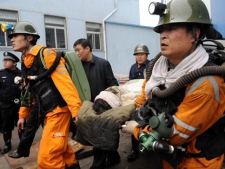In this photo released by China's Xinhua News Agency, rescuers carry an injured miner out of the Qianqiu Coal Mine of Yima Coal Group in Sanmenxia City, central China's Henan Province, Friday, Nov. 4, 2011. Rescuers pulled seven injured miners to the surface Friday and were trying to reach 50 others trapped after a rock explosion Thursday in the coal mine, the state media reported. (AP Photo/Xinhua, Zhu Xiang)
