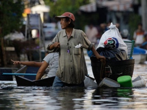 A Thai man uses an improvised float to carry items along a flooded street in Bangkok, Thailand, Sunday, Nov. 6, 2011. The polluted black water continued its march into Bangkok and authorities ordered a spate of new evacuations in the sprawling capital. (AP Photo/Aaron Favila)