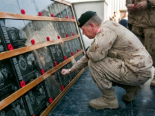 Canadian Forces Major General Jon Vance places poppies on the plaques honouring the country's fallen soldiers during the last Remembrance Day ceremony at Kandahar Air Field Friday, Nov. 11, 2011 in Kandahar, Afghanistan. (THE CANADIAN PRESS/Ryan Remiorz)