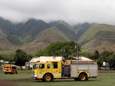 Emergency vehicles from are positioned near Kilohana Elementary School on Molokai, in Hawaii, Thursday, Nov. 10, 2011, after a helicopter taking four tourists on an excursion over the island crashed into a mountainside near the school killing all of the tourists and the pilot, according to authorities. (AP Photo/Joey Salamon)