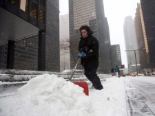 A man clears snow in Toronto's financial district Wednesday, Feb. 2, 2011. (THE CANADIAN PRESS/Darren Calabrese)