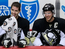 Pittsburgh Penguins' Sidney Crosby, right, and Pascal Dupuis sit on the bench during a timeout in the first period of an NHL hockey game against the New York Islanders in Pittsburgh on Monday, Nov. 21, 2011. The Penguins won 5-0, with Crosby getting two goals and two assists. (AP Photo/Gene J. Puskar)