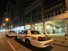 Toronto police cars are parked outside a condo building on Queens Quay, near Lower Simcoe Street, after a man was shot in the leg early Friday, Nov. 25, 2011. (CP24/Tom Stefanac)