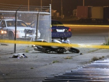 A motorcycle rests on the ground after a crash involving a shooting suspect near Cherry Street and Unwin Avenue early Friday, Nov. 25, 2011. Before the crash, a man was shot in the leg at a condo building on Queens Quay. (CP24/Tom Stefanac)