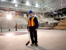 Bruce Piercey, a spokesman for Ryerson University, holds a pair of hockey sticks before a photo opportunity as the Peter Gilgan Athletic Centre, which forms part of Ryerson University's athletic facility, is unveiled in Toronto on Tuesday, Nov. 29, 2011. The centre, which is still under construction, stands on the site of Maple Leaf Gardens, the former home of the Toronto Maple Leafs. (THE CANADIAN PRESS/Chris Young)