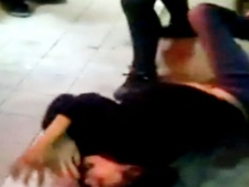 A woman is seen as she is beaten in this image taken from a video on YouTube. Police are trying to identify the woman's attackers. 