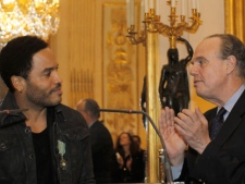 U.S. singer Lenny Kravitz delivers a speech after being awarded "Officier dans l'Ordre des Arts et des Lettres" (Officer of Arts and Literature) by French Culture minister Frederic Mitterrand, right, in Paris, Wednesday, Nov. 30, 2011. (AP Photo / Christophe Ena)