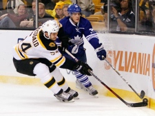Toronto Maple Leafs' Matt Frattin (39) battles for the puck with Boston Bruins' Adam McQuaid (54) in the first period of an NHL hockey game in Boston, on Saturday, Dec. 3, 2011. (AP Photo/Michael Dwyer)