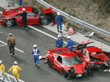 Police officers investigate damaged Ferrari cars at the site of a traffic accident on the Chugoku Expressway in Shimonoseki, southwestern Japan, Sunday, Dec. 4, 2011. Thirteen sports cars, including eight Ferraris, a Lamborghini and two Mercedes-Benz, were involved in the accident, slightly injuring 10 people. (AP Photo/Kyodo News)