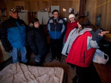 Grand Chief Stan Loutit, Band Chief Theresa Spence, MP Charlie Angus and NDP Interim leader Nycole Turmel listen to a resident of Attawapiskat speak about her temporary lodging in a shelter Tuesday, Nov. 29, 2011. (THE CANADIAN PRESS/Adrian Wyld)