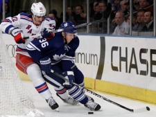 New York Rangers center Brian Boyle (22) and Toronto Maple Leafs defenseman Carl Gunnarsson (36) skate behind the Maple Leafs goal in the second period of an NHL hockey game at Madison Square Garden in New York, Monday, Dec. 5, 2011. (AP Photo/Kathy Willens)