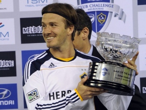 David Beckham of the LA Galaxy holds the trophy he won the Man of the Match award in their soccer friendly match against the Melbourne Victory in Melbourne, Australia, Tuesday, Dec. 6, 2011. ( AP Photo/Andrew Brownbill)