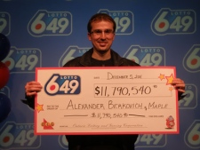 Alexander Berkovich, 27, of Maple, Ont., accepts his cheque for $11.8-million on Monday, Dec. 6, 2011. 