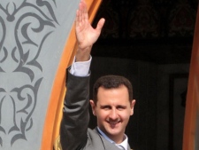In this photo released by the Syrian official news agency SANA, Syrian President Bashar Assad waves to his supporters after he attended the prayer of Eid Al Adha, at the al-Nour Mosque in the northern town of Raqqa, Syria, on Sunday, Nov. 6, 2011. (AP Photo/SANA) 