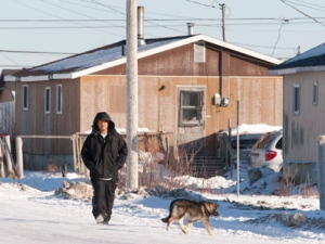 A man walks down the street in Attawapiskat, Ont., Tuesday, Nov. 29, 2011. (THE CANADIAN PRESS/Adrian Wyld)