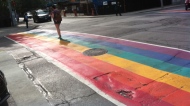 A pedestrian in Toronto's gay village walks along a crosswalk painted in rainbow colours in honour of WorldPride festivities. (Joshua Freeman/CP24)