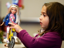 Angelica Pupo, 5, plays with a Barbie doll during the Canadian Toy Association's eighth annual Hot Toys for the Holidays event in Toronto on Monday, Nov. 1, 2010. (THE CANADIAN PRESS/Nathan Denette)