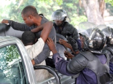 Young men suspected of being militant supporters of opposition candidate Etienne Tshisekedi are forced into a police truck as they are arrested near opposition party headquarters in the Limete district of Kinshasa, Congo, Monday, Dec. 12, 2011. (AP Photo/John Bompengo)