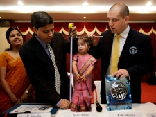 Guinness World Records adjudicator Rob Molloy, right, and Dr. Manoj Pahukar of Wockhardt hospital, second left, measure Jyoti Amge at a press conference in Nagpur, India, Friday, Dec. 16, 2011. Amge, 18, was declared shortest woman in the world measuring 62.8 centimeters (24.7 inches) by the Guinness World Records. (AP Photo/Manish Swarup)