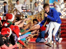 In this photo provided by Disney, Justin Bieber performs while taping a segment for the "Disney Parks Christmas Day Parade" TV special at the Magic Kingdom park at Walt Disney World in Lake Buena Vista, Fla. on Saturday, Dec. 3, 2011. (AP Photo/Disney, Mark Ashman)
