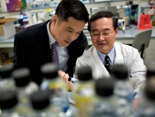 In this Oct. 17, 2006, photo, Dr. Chil-Yong Kang, professor of virology, right, shows a visitor around his lab at the University of Western Ontario's Schulich School of Medicine. (THE CANADIAN PRESS/Geoff Robins)
