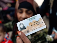 Egyptian Zeinab al-Shogery, 58 shows her identification card while she prepares to vote at a polling center in Giza, Egypt Wednesday, Dec. 21, 2011. Voting in election runoffs for Egypt's first parliament since Hosni Mubarak's ouster resumed on Wednesday without the long lines outside polling centers seen in previous rounds of the staggered vote. (AP Photo/Nasser Nasser)