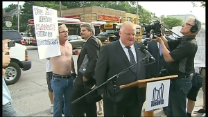 Ford confronted by shirtless protesters