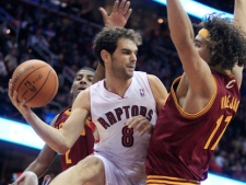 Toronto Raptors' Jose Calderon (8) tries to pass between Cleveland Cavaliers' Anderson Varejao )17), from Brazil, and Kyrie Irving (2) in the first quarter of an NBA basketball game Monday, Dec. 26, 2011, in Cleveland. (AP Photo/Tony Dejak)