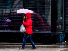 A woman walks with a broken umbrella on Spadina Avenue in Toronto on Tuesday, Dec. 27, 2011. (THE CANADIAN PRESS/Pawel Dwulit)