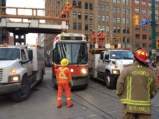 Crews remove a live wire off a streetcar on Spadina Avenue at Adelaide Street on Thursday, Dec. 29, 2011. The operator and four passengers were stuck on the streetcar until the wire was removed. (CP24/Cam Woolley)