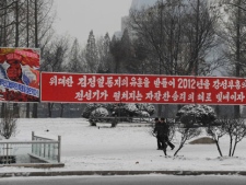 Two North Koreans pass by a New Year message on a street in Pyongyang on Sunday, Jan. 1, 2012. The sign reads "Glorify 2012 as a year of proud victory, when an era of prosperity unfolds, true to instructions of the Great General Kim Jong Il". (AP Photo)